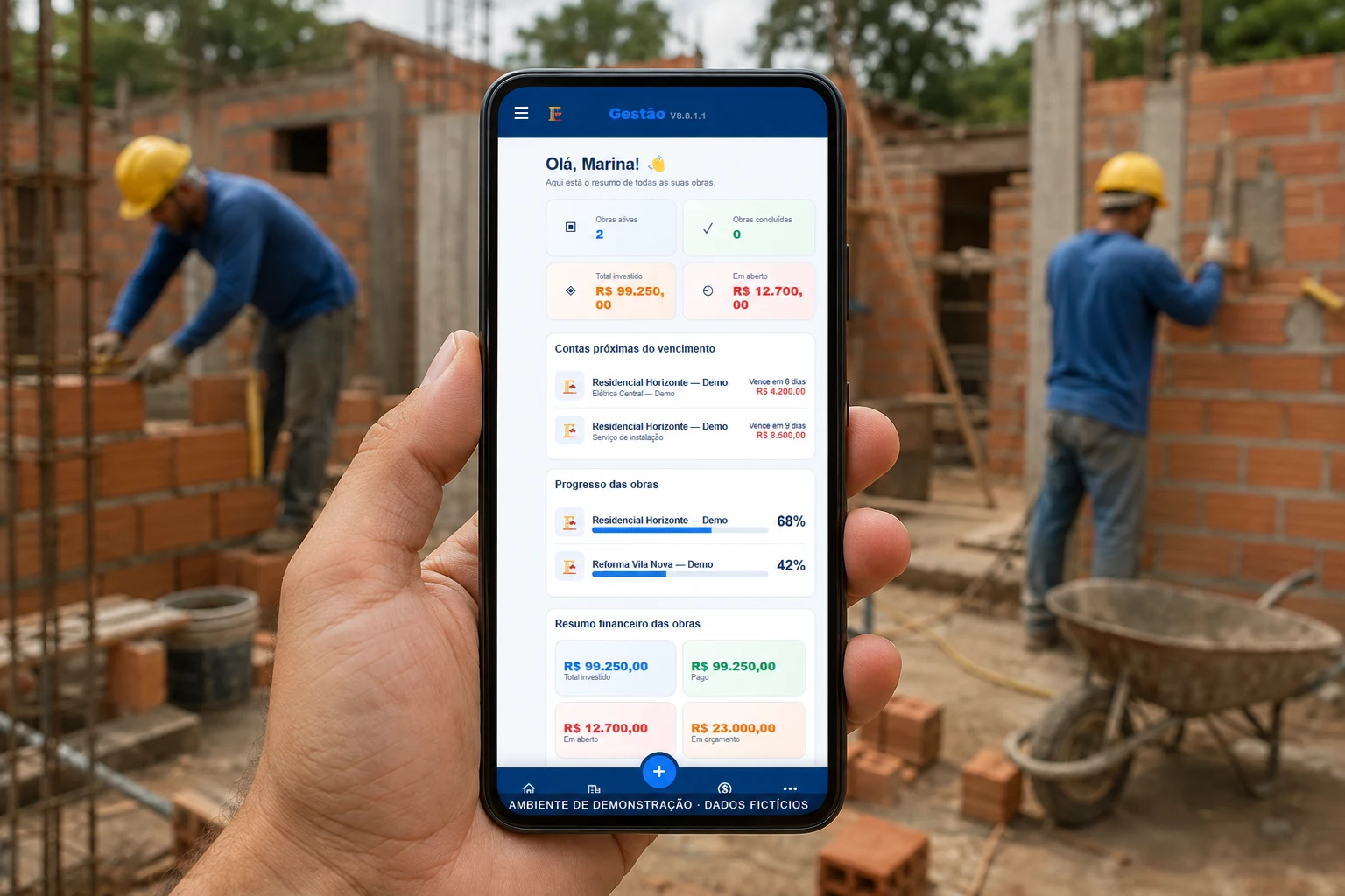 Celular com a tela do ObraGestão em primeiro plano, com trabalhadores executando a obra ao fundo